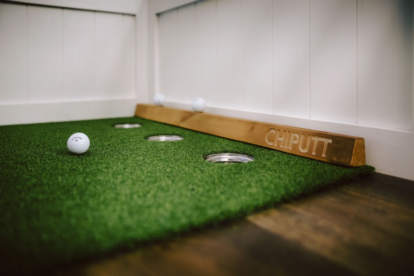 Indoor putting green with a golf training aid