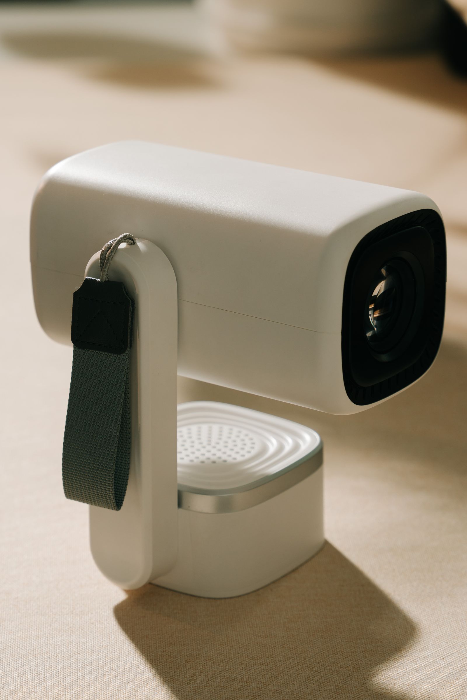 A compact modern video projector product shot on a neutral background