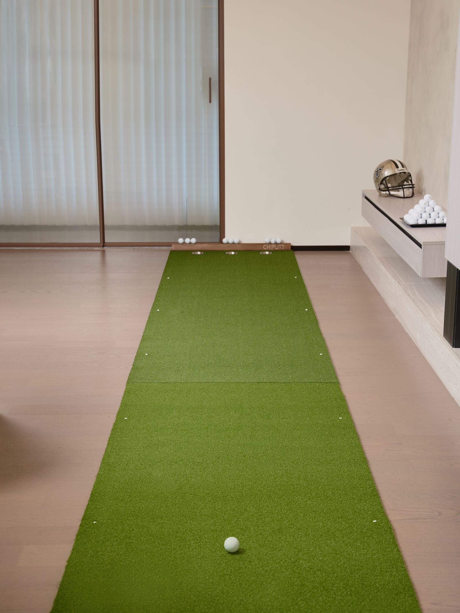 An indoor golf putting green with a training aid on artificial turf