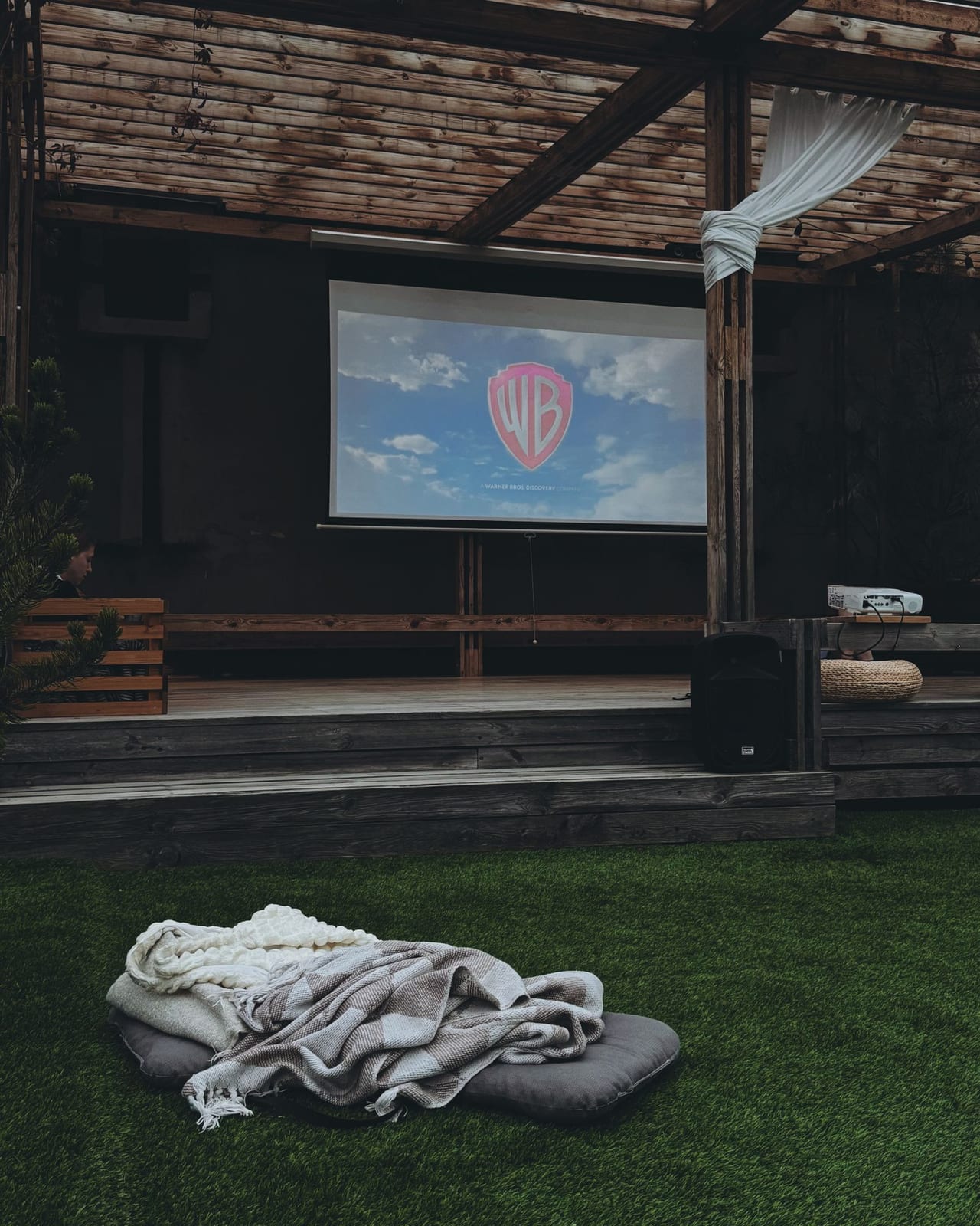 A projector beam throwing a bright image across a screen in a darkened room