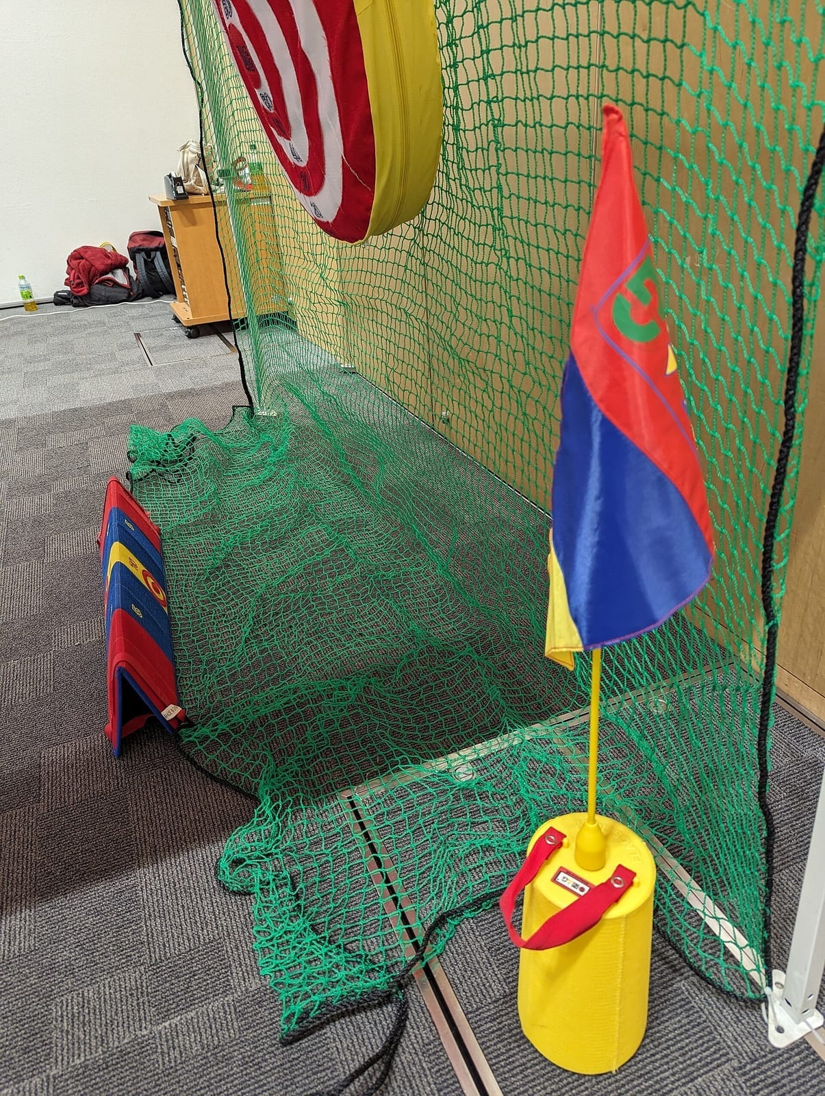 A golf simulator bay with a course projected across the full width of the impact screen
