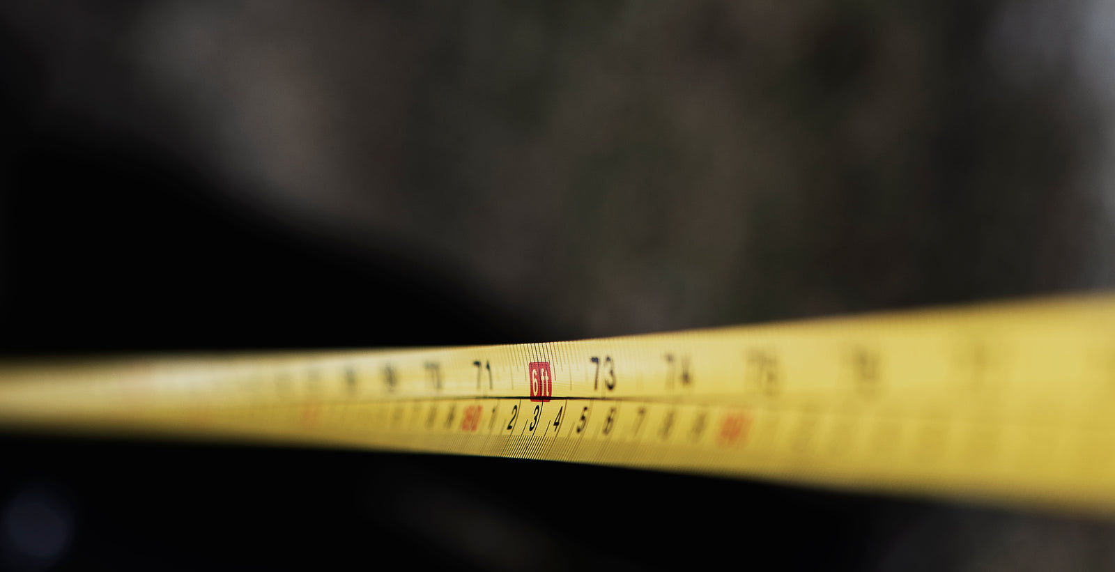A tape measure showing the six-foot mark against a black background