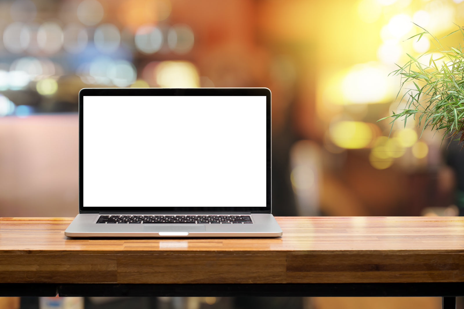 A laptop computer sitting on a wooden table
