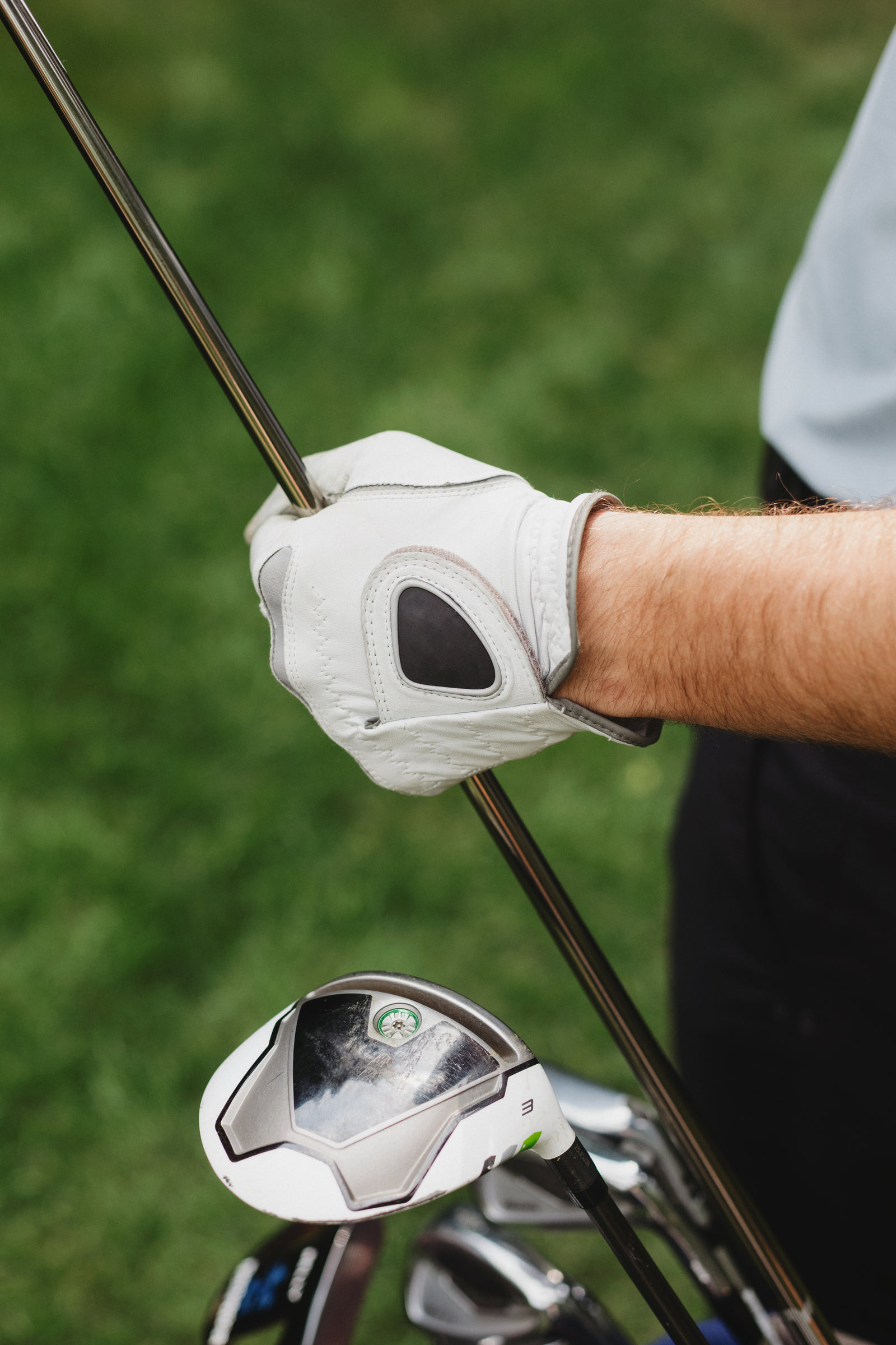 A golfer's gloved hands holding a club while selecting the next shot