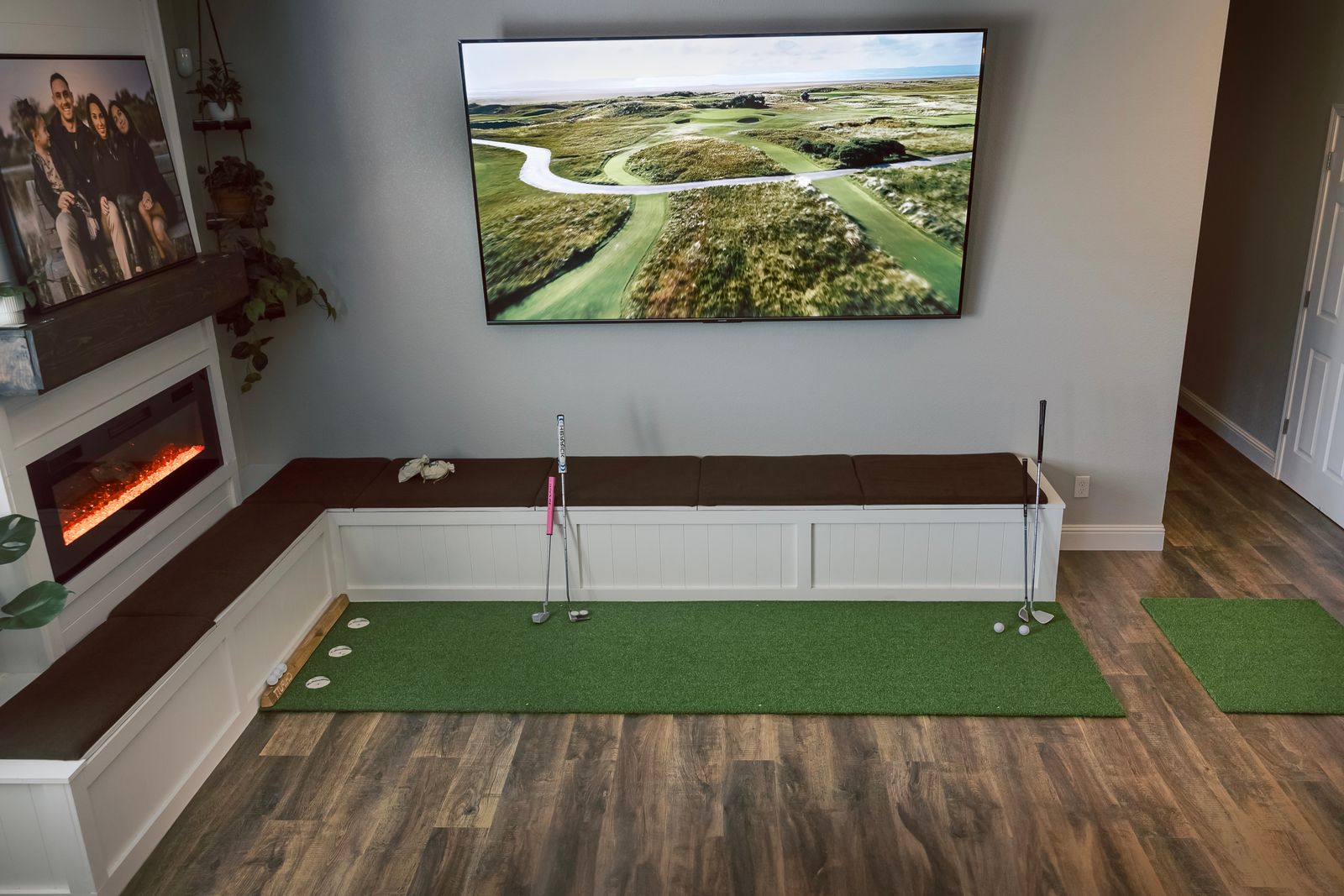 An indoor putting mat with a virtual golf course displayed on a projector screen