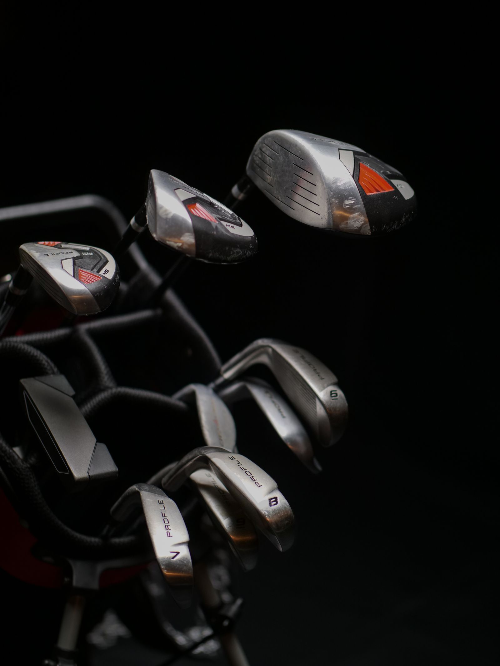 A detailed view of a set of golf clubs with a metallic finish